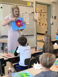 Student teacher working with students in an elementary school classroom