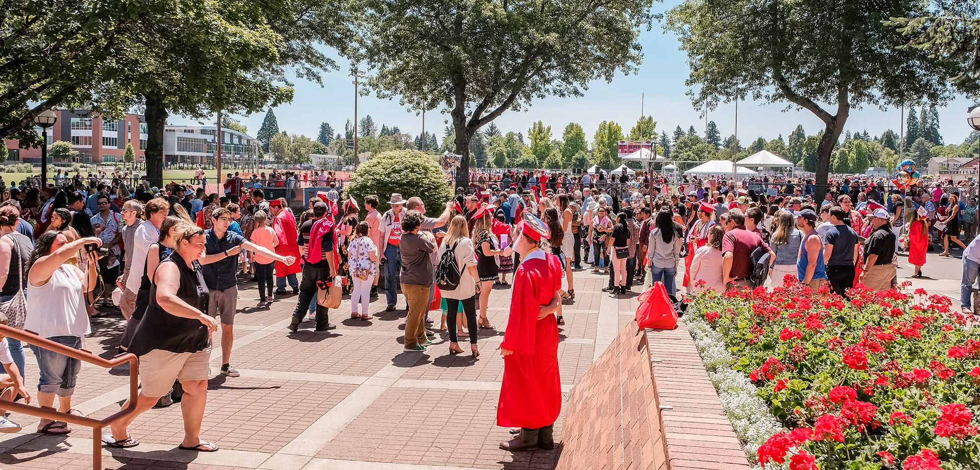 2019, commencement, exterior WOU grads gathering outside.
