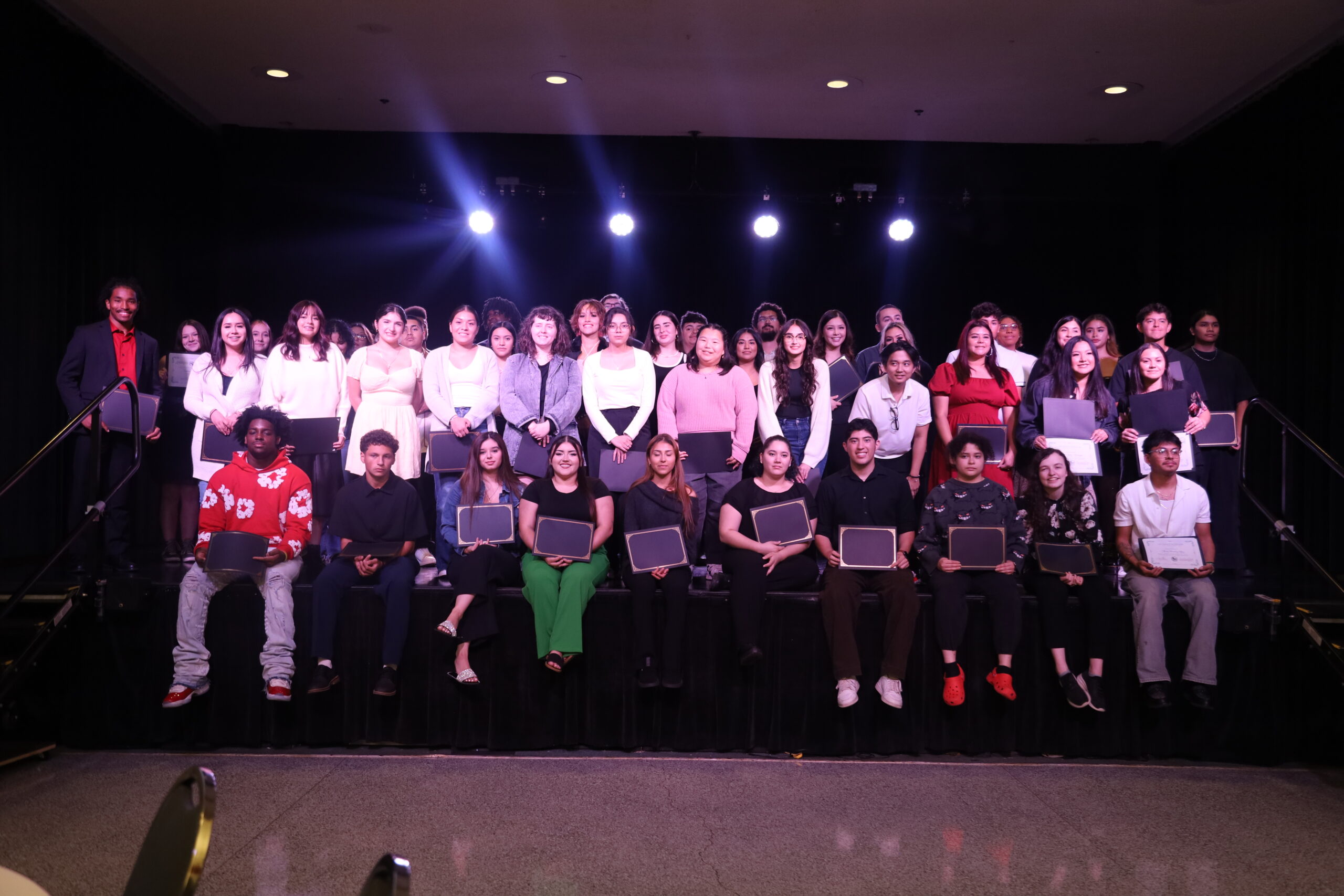 IMG_0747 (1) Group of students with backpacks sitting in a circle on grass